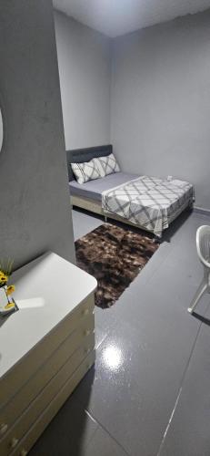 a bedroom with a bed and a table and a chair at Boa opção in Manaus
