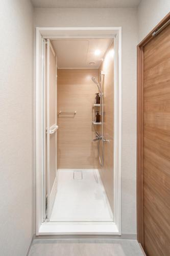 a bathroom with a shower with a glass door at 365Ueno in Tokyo