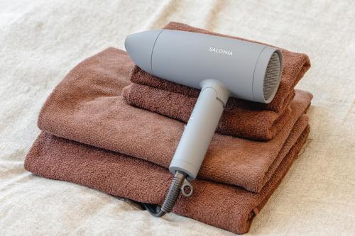 a hair dryer sitting on a pile of towels at 365Ueno in Tokyo
