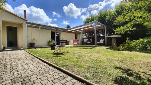 a backyard of a house with a patio at Charmante maison t3 avec 2 chambres et jardin clos in Carquefou