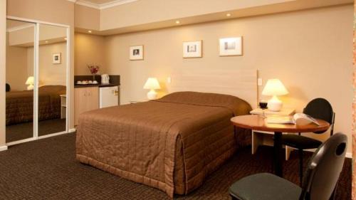 ein Hotelzimmer mit einem Bett und einem Tisch in der Unterkunft Motel Le Grande in Albany