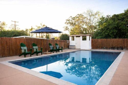 a swimming pool with two chairs and an umbrella at Pool Oasis Central Villa in El Cajon