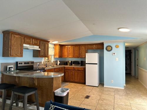 a kitchen with wooden cabinets and a white refrigerator at spacious one Bedroom mobil home in Harlingen