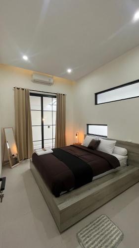 a bedroom with a large bed and a large window at Patria Villa Kayen with Private Pool in Yogyakarta