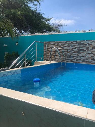 een groot zwembad met blauw water en een trap bij kalani cabin in Ríohacha