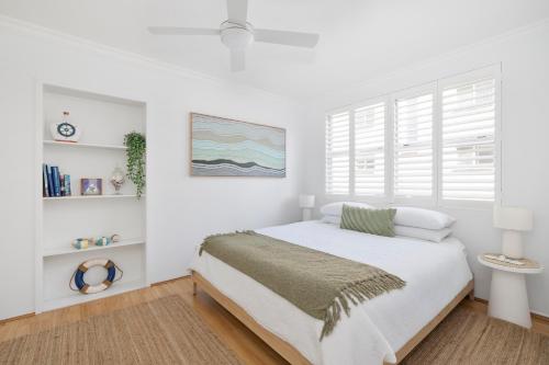 a white bedroom with a bed and a window at Sunny Manly Escape 2 min walk to beach in Sydney