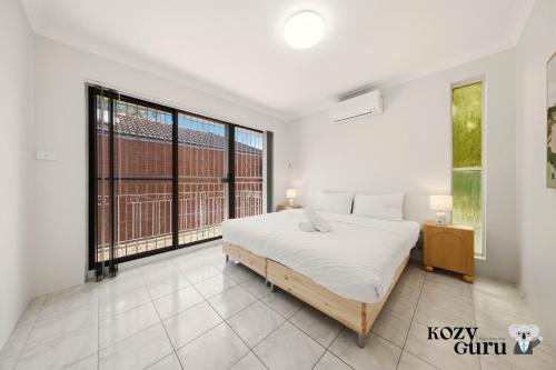 En eller flere senge i et værelse på KozyGuru | Cabramatta | Spacious Family Townhouse