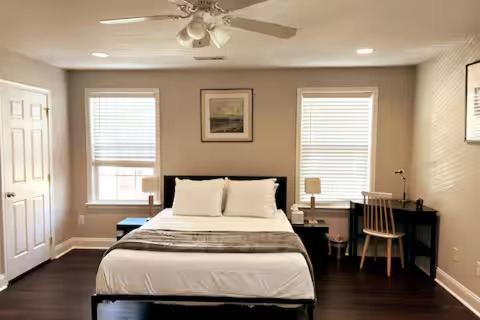 a bedroom with a bed and a desk and windows at 25 Lux King Suite 1 - Private Bath, Nonsmoking in Arlington