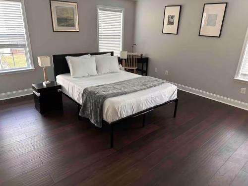 a bedroom with a bed with white sheets and wood floors at 25 Lux King Suite 1 - Private Bath, Nonsmoking in Arlington