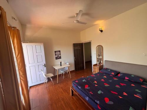 een slaapkamer met een bed, een tafel en een bureau bij Empra Exotica in Madikeri