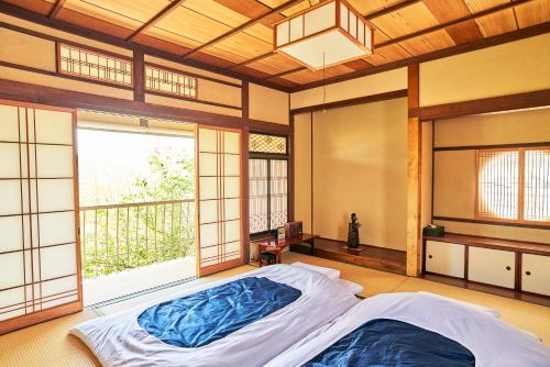 een slaapkamer met een bed en een groot raam bij uedaonsen jukyuan in Ueda