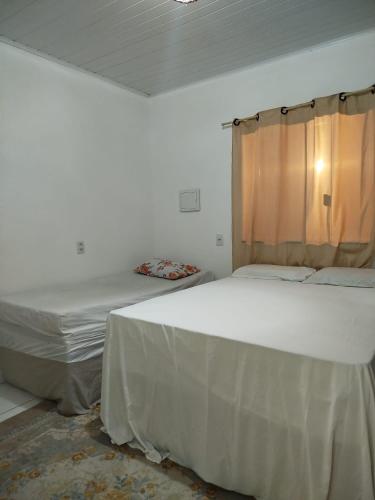 een slaapkamer met twee bedden en een raam bij Ambiente Família e acolhedor in Porto Seguro