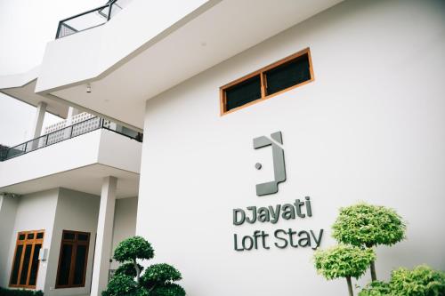 une maison blanche avec un panneau indiquant « Dixon Lot Stay » dans l'établissement Djayati Loft Stay, à Timuran