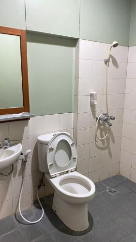 a bathroom with a toilet and a sink at Sang Surya Guest House in Bandung