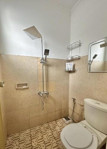 a bathroom with a shower and a toilet in it at Spacious House - Ngemplak, Surakarta in Kadipiro