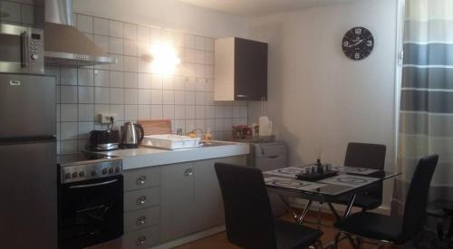 a kitchen with a table with chairs and a stove at Apartments Center Colmar in Colmar