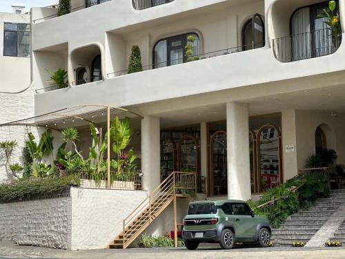 un SUV verde parcheggiato di fronte a un edificio di Túi Ba Gang Central Hotel a Da Lat