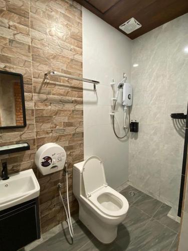a bathroom with a toilet and a sink at Bricks Guesthouse in Tanah Rata