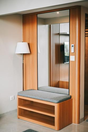 a room with a bed with a mirror and a lamp at Djayati Loft Stay in Yogyakarta