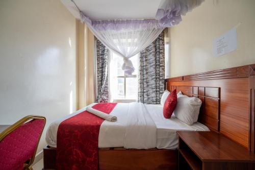 a bedroom with a large bed and a window at Capital comfort Hotel Ambala Rd in Nairobi