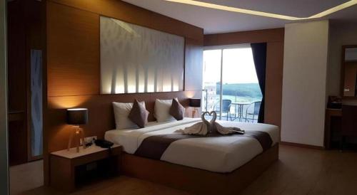 een slaapkamer met een groot bed met een groot raam bij The Vista Hotel By Satit Group in Sadao