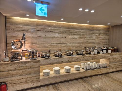 Un mostrador con ollas y sartenes en una pared de madera. en Hotel Uri&, en Seúl