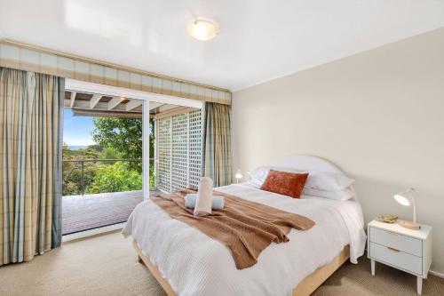 een slaapkamer met een bed en een groot raam bij Louttit Bay Lookout in Lorne