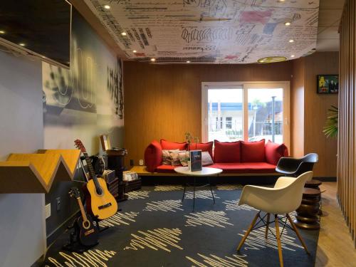 een woonkamer met een rode bank en gitaren bij ibis Aracaju in Aracaju