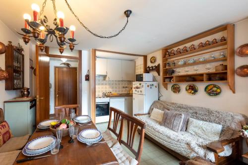 een keuken en woonkamer met een tafel en een bank bij Residence Dolonne - Happy Rentals in Courmayeur
