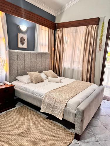 a bedroom with a large bed and a large window at 3Bedroom Villa-Shanzu, Mombasa in Mombasa