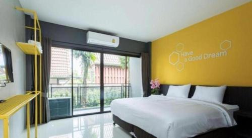 a bedroom with a large bed and a large window at Seven bee boutique hotel in Surin