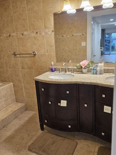 a bathroom with a sink and a shower at 2 Bed, 1 Bath- Main floor, 2 Parking- Licensed in Oakville