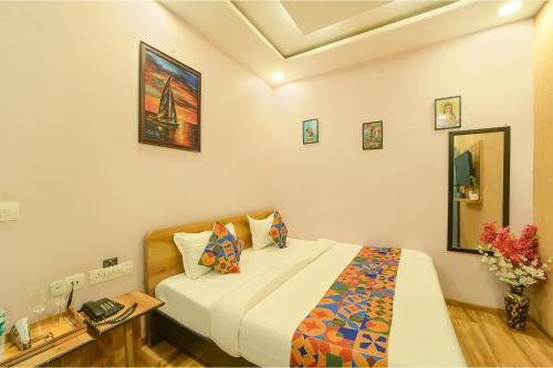 una camera da letto con un letto e una scrivania con un telefono di FabHotel Blooming Beds Pearl a Jaipur