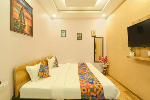 una camera da letto con un letto e una TV a schermo piatto di FabHotel Blooming Beds Pearl a Jaipur