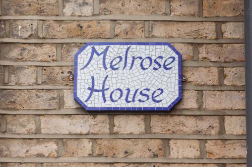 a sign on a brick wall with the words niece house at Melrose House in London