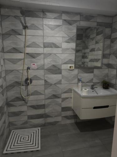 un bagno con doccia, lavandino e specchio di Shantel a Haifa