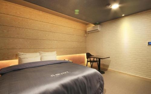 a bedroom with a bed and a desk in it at SU Motel in Gumi