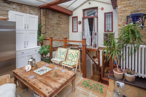 a patio with a wooden table and chairs on a balcony at Melrose House in London
