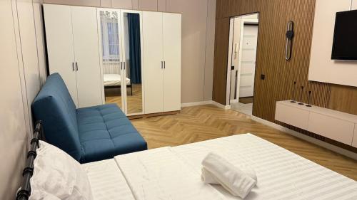 a room with a bed and a chair and a television at Kurmangazy in Zhezdi