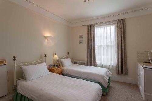 a hotel room with two beds and a window at Melrose House in London