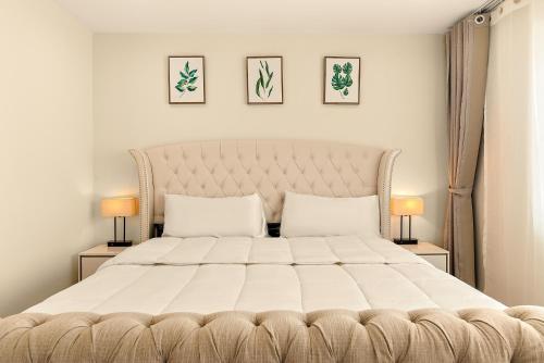 a bedroom with a large white bed with two lamps at Lyn's Stay in Westminster