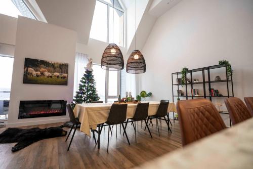 een eetkamer met een tafel en een kerstboom bij 404 - Nature & Luxury Penthouse - View & Pool in Baie-Saint-Paul