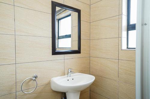 un baño con lavabo y espejo en Royal Palm, en Mokopane