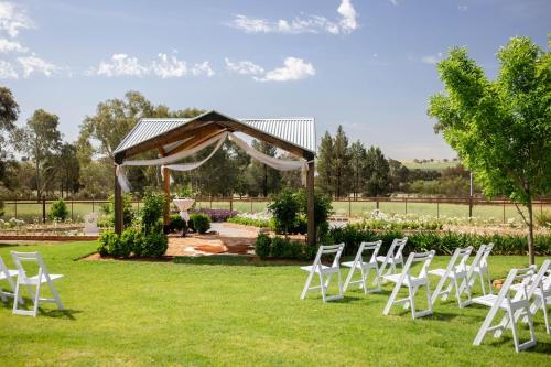 a group of white chairs sitting in the grass at Drovers Run B&B and Events Venue 