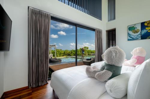 two teddy bears sitting on a couch in a bedroom at Madifushi Private Island- Stay 5 Nights or More & Enjoy Free Roundtrip DOMESTIC FLIGHT & SPEEDBOAT in Meemu Atoll