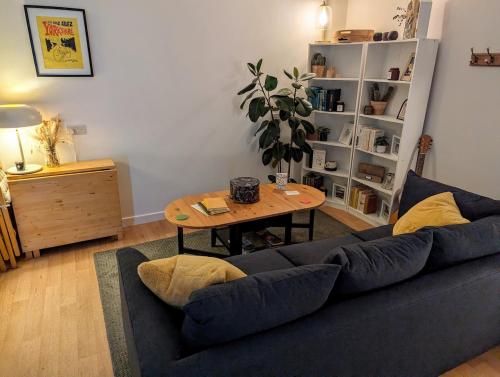 een woonkamer met een blauwe bank en een tafel bij Loxley View Guest House in Hillsborough