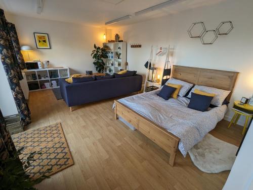 een slaapkamer met een groot bed en een blauwe bank bij Loxley View Guest House in Hillsborough