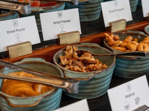 een buffet met kommen eten op tafel bij V Villas Hua Hin - MGallery Collection in Hua Hin