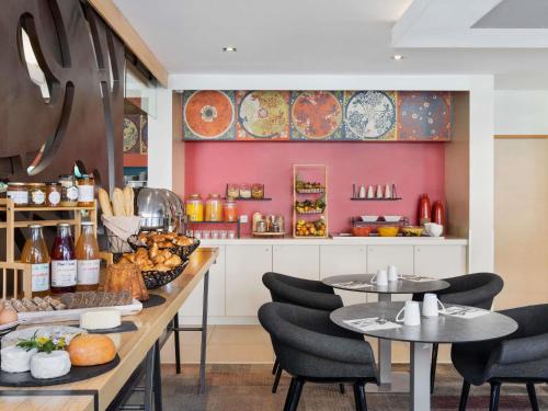 Mercure Amiens Cathédrale في أميان: مطعم بطاولتين وكراسي وكاونتر