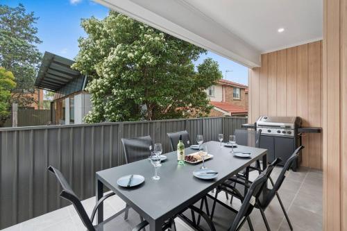 a table and chairs on a patio with a grill at Saltwater Escape - Live the Sand and Surf Lifestyle in Wollongong
